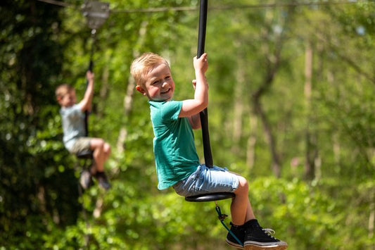 Child on a zip line in a forest setting at BeWILDerwood. BeWILDerwood is an award-winning, whimsical outdoor woodland adventure park for families, with locations in England. Based on books by author Tom Blofeld, it offers imaginative, nature-based play, including treetop mazes, wobbly wires, slippery slides, boat rides, and character-driven storytelling for children aged 2 to 12.