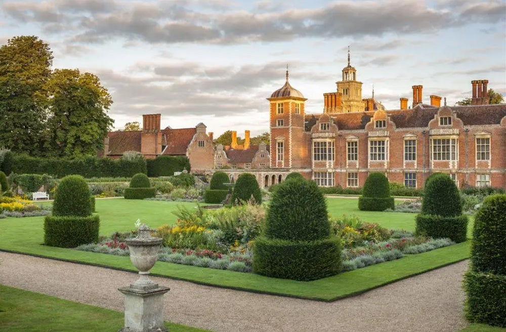 Carefully manicured gardens  and pathways of Blickling Hall. Blickling Hall is a premier 17th-century Jacobean mansion in Norfolk, England, managed by the National Trust. Famous for its red-brick, gabled architecture, it features a 123-foot Long Gallery library, a grand staircase, and a storied history as the likely birthplace of Anne Boleyn. The hall is set within 4,600+ acres of parkland and 55 acres of manicured gardens. 