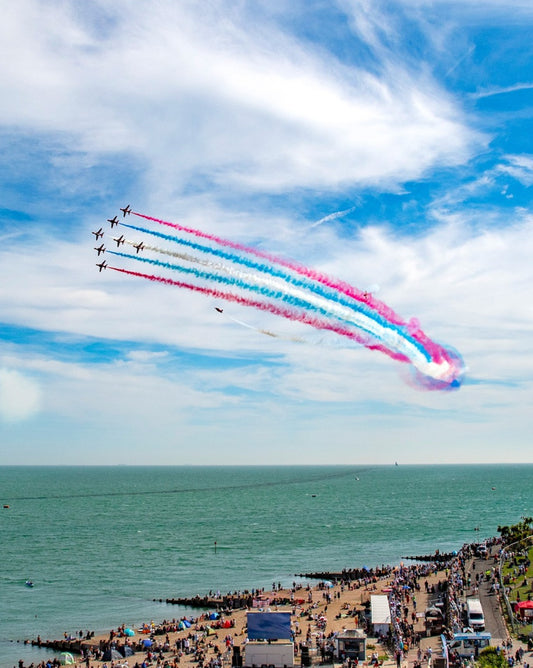Red Arrows performing a flyover with coloured smoke trails over Eastbourne sea front at the Airbourne: Eastbourne International Airs how is a premier, award-winning free four-day event held annually in August along the East Sussex coastline. It features spectacular aerial displays from RAF and international teams, including fast jets and historic warbirds over a 2-mile seafront, complemented by military exhibitions, ground entertainment, and evening fireworks.