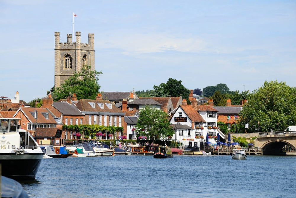 Henley on Thames with boats and a church tower in the background. Henley-on-Thames is a picturesque, historic market town in Oxfordshire, England, renowned for its stunning riverside location on the Thames, bordered by the Chiltern Hills. As the home of the world-famous Henley Royal Regatta, it is a hub for rowing, boating, and summer festivals, blending charming Georgian architecture, independent shops, and fine dining.