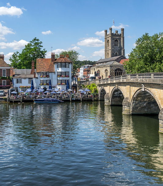 Henley on Thames scene with a bridge over a river, buildings, and trees under a blue sky. Henley-on-Thames is a picturesque, historic market town in Oxfordshire, England, renowned for its stunning riverside location on the Thames, bordered by the Chiltern Hills. As the home of the world-famous Henley Royal Regatta, it is a hub for rowing, boating, and summer festivals, blending charming Georgian architecture, independent shops, and fine dining.