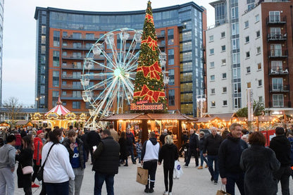 Portsmouth Christmas market with a Ferris wheel and decorated tree in an urban setting