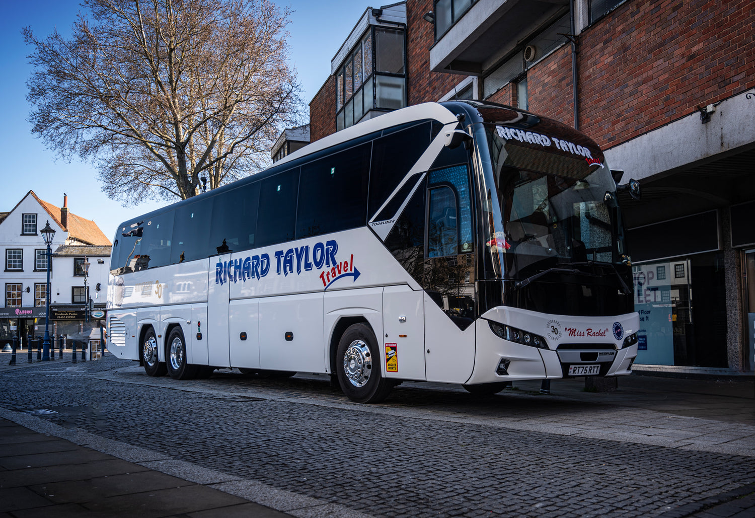 Coach bus with 'Richard Taylor Travel' branding on a street.