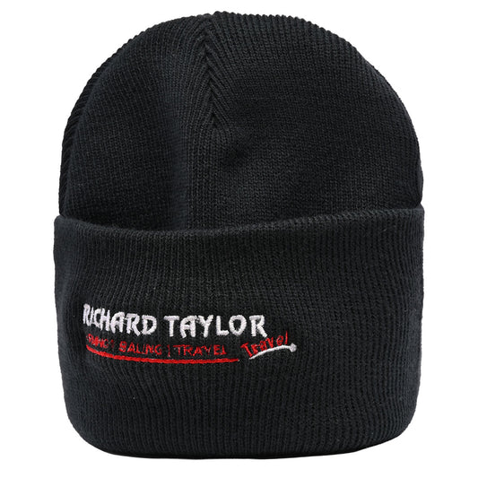 A black ribbed knit beanie hat with a folded cuff, featuring white and red embroidered text reading 'RICHARD TAYLOR TRAVEL' on the front, shown against a plain white background.