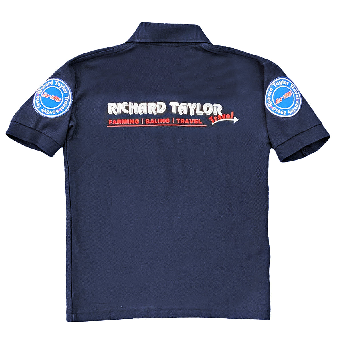 A Richard Taylor Travel navy blue short-sleeve polo shirt shown from the back, featuring 'RICHARD TAYLOR TRAVEL' in white across the upper back, 'FARMING | BALING | TRAVEL' in red below it, and circular blue-and-white with patches on both sleeves.