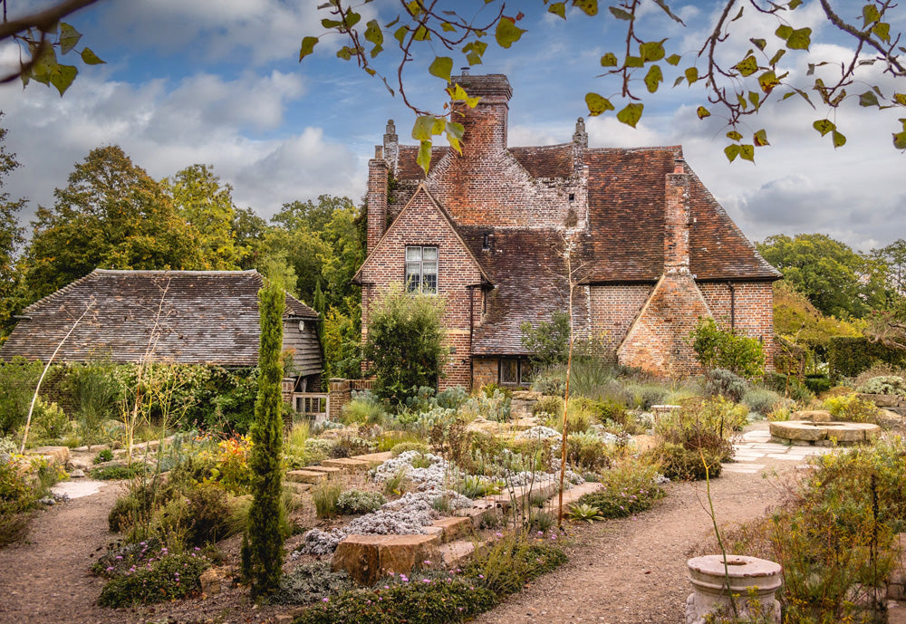 Priests House and gardens at Sissinghurst Castle. Sissinghurst Castle, located in Kent, England, is a world-renowned, romantic garden designed by Vita Sackville-West and Harold Nicolson in the 1930s within the ruins of an Elizabethan manor. Known for its intimate "garden rooms" separated by high hedges and brick walls, it features the iconic White Garden and a towering Tudor gatehouse.