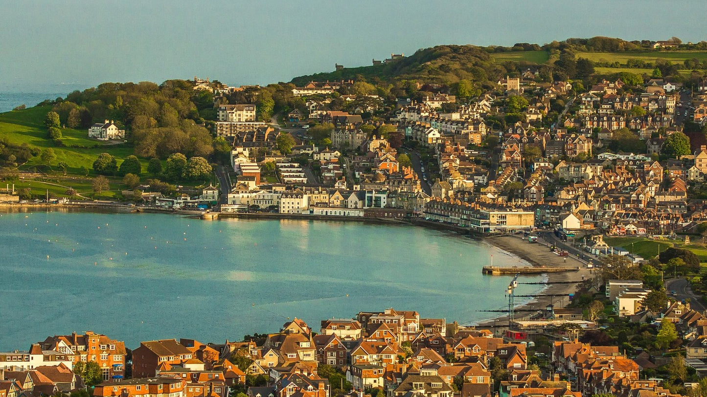 Swanage is a charming, traditional Victorian seaside town located on the Isle of Purbeck in Dorset, England, renowned as a family-friendly destination on the Jurassic Coast World Heritage Site. Known for its sheltered, golden sandy bay, clear waters, and nostalgic atmosphere, it features a restored pier, steam railway, and close proximity to dramatic coastal walking paths.