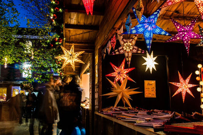 Decorative star lights hanging from a wooden shop roof at York festive market.
