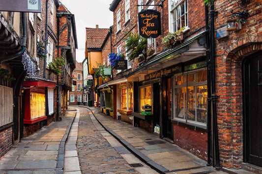  narrow street with historic buildings and shops in the York Shambles. York is a historic, walled city in North Yorkshire, England, renowned for its 2,000-year heritage, Roman roots, and Viking history. Located on the River Ouse, it features the massive Gothic cathedral York Minster and well-preserved medieval streets like The Shambles. As a major tourist destination, it offers a compact, walkable center, city walls, and museums like the Jorvik Viking Centre