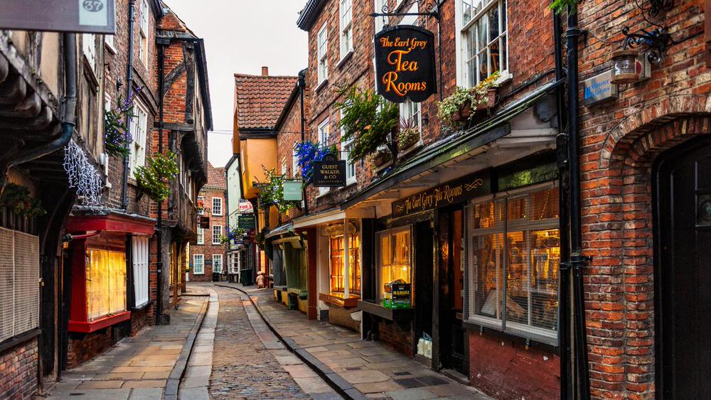 The Shambles is a famous, narrow, cobbled street in York, England, regarded as one of Europe's best-preserved medieval shopping streets. Dating back to the 14th century, it features overhanging timber-framed buildings that previously housed butchers, with some original meat hooks and shelves still visible. It is frequently linked to Harry Potter’s Diagon Alley.