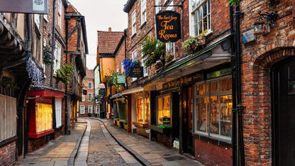 The Shambles is a famous, narrow, cobbled street in York, England, regarded as one of Europe's best-preserved medieval shopping streets. Dating back to the 14th century, it features overhanging timber-framed buildings that previously housed butchers, with some original meat hooks and shelves still visible. It is frequently linked to Harry Potter’s Diagon Alley.