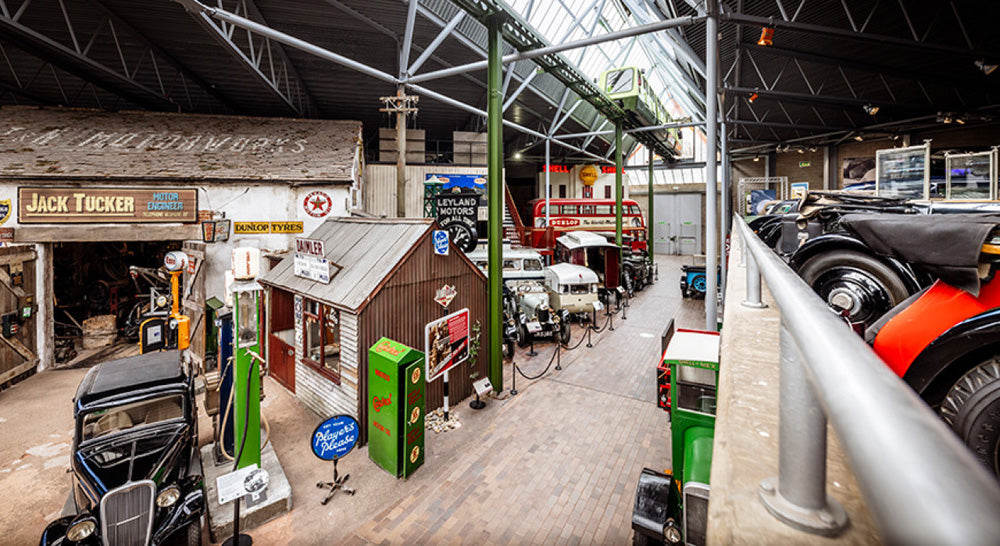 Garage Scene in Beaulieu Motor Museum. The National Motor Museum at Beaulieu, located in England's New Forest, houses a world-famous collection of over 280 vehicles and motoring memorabilia, documenting British motoring history. Founded in 1952, the museum showcases iconic cars, land speed record breakers, Formula 1 machines, and classic motorcycles, alongside exhibits like "On Screen Cars" and "World of Top Gear"