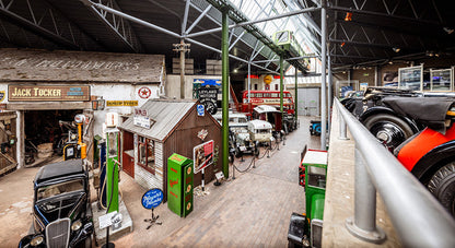 Garage Scene in Beaulieu Motor Museum. The National Motor Museum at Beaulieu, located in England's New Forest, houses a world-famous collection of over 280 vehicles and motoring memorabilia, documenting British motoring history. Founded in 1952, the museum showcases iconic cars, land speed record breakers, Formula 1 machines, and classic motorcycles, alongside exhibits like "On Screen Cars" and "World of Top Gear"